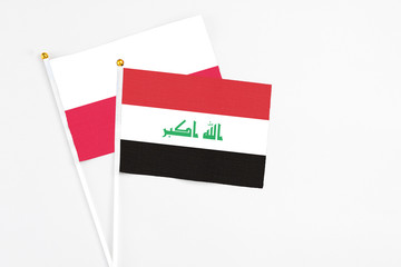 Iraq and Poland stick flags on white background. High quality fabric, miniature national flag. Peaceful global concept.White floor for copy space.