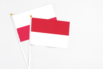 Indonesia and Poland stick flags on white background. High quality fabric, miniature national flag. Peaceful global concept.White floor for copy space.