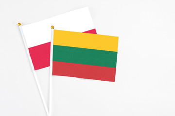 Lithuania and Poland stick flags on white background. High quality fabric, miniature national flag. Peaceful global concept.White floor for copy space.