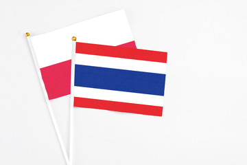 Thailand and Poland stick flags on white background. High quality fabric, miniature national flag. Peaceful global concept.White floor for copy space.