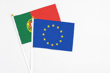 European Union and Portugal stick flags on white background. High quality fabric, miniature national flag. Peaceful global concept.White floor for copy space.