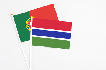 Gambia and Portugal stick flags on white background. High quality fabric, miniature national flag. Peaceful global concept.White floor for copy space.