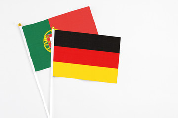 Germany and Portugal stick flags on white background. High quality fabric, miniature national flag. Peaceful global concept.White floor for copy space.