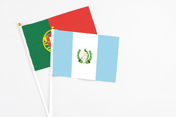 Guatemala and Portugal stick flags on white background. High quality fabric, miniature national flag. Peaceful global concept.White floor for copy space.