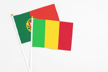 Mali and Portugal stick flags on white background. High quality fabric, miniature national flag. Peaceful global concept.White floor for copy space.