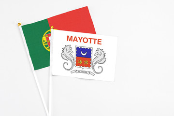 Mayotte and Portugal stick flags on white background. High quality fabric, miniature national flag. Peaceful global concept.White floor for copy space.