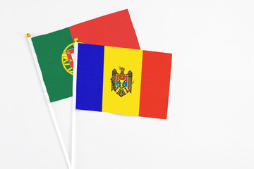Fototapeta premium Moldova and Portugal stick flags on white background. High quality fabric, miniature national flag. Peaceful global concept.White floor for copy space.