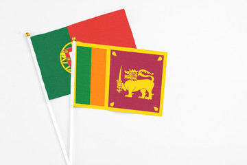 Sri Lanka and Portugal stick flags on white background. High quality fabric, miniature national flag. Peaceful global concept.White floor for copy space.