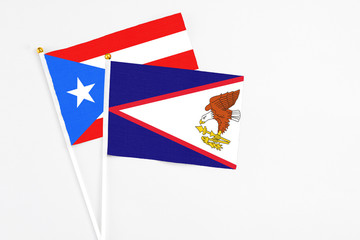 Obraz premium American Samoa and Puerto Rico stick flags on white background. High quality fabric, miniature national flag. Peaceful global concept.White floor for copy space.