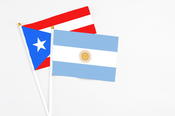 Argentina and Puerto Rico stick flags on white background. High quality fabric, miniature national flag. Peaceful global concept.White floor for copy space.
