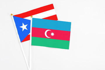 Azerbaijan and Puerto Rico stick flags on white background. High quality fabric, miniature national flag. Peaceful global concept.White floor for copy space.