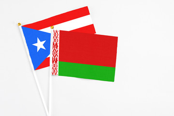 Belarus and Puerto Rico stick flags on white background. High quality fabric, miniature national flag. Peaceful global concept.White floor for copy space.