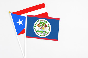 Belize and Puerto Rico stick flags on white background. High quality fabric, miniature national flag. Peaceful global concept.White floor for copy space.