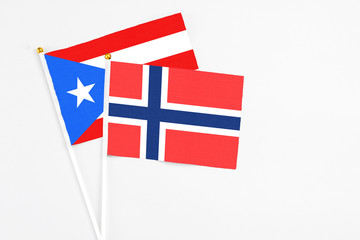 Bouvet Islands and Puerto Rico stick flags on white background. High quality fabric, miniature national flag. Peaceful global concept.White floor for copy space.
