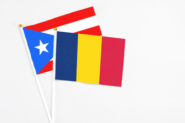 Chad and Puerto Rico stick flags on white background. High quality fabric, miniature national flag. Peaceful global concept.White floor for copy space.