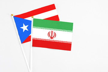 Iran and Puerto Rico stick flags on white background. High quality fabric, miniature national flag. Peaceful global concept.White floor for copy space.