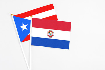 Paraguay and Puerto Rico stick flags on white background. High quality fabric, miniature national flag. Peaceful global concept.White floor for copy space.