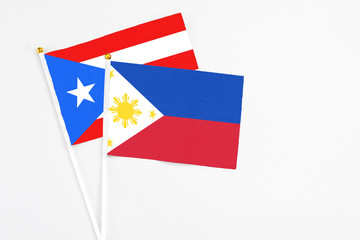 Philippines and Puerto Rico stick flags on white background. High quality fabric, miniature national flag. Peaceful global concept.White floor for copy space.