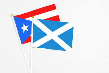 Scotland and Puerto Rico stick flags on white background. High quality fabric, miniature national flag. Peaceful global concept.White floor for copy space.