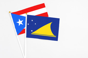 Tokelau and Puerto Rico stick flags on white background. High quality fabric, miniature national flag. Peaceful global concept.White floor for copy space.