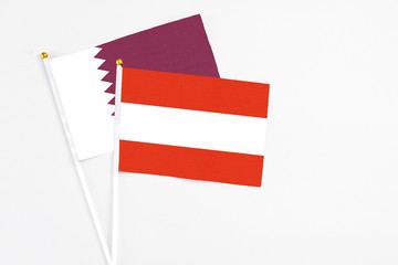 Austria and Qatar stick flags on white background. High quality fabric, miniature national flag. Peaceful global concept.White floor for copy space.