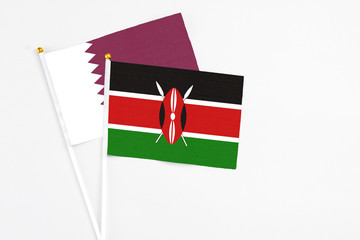 Kenya and Qatar stick flags on white background. High quality fabric, miniature national flag. Peaceful global concept.White floor for copy space.