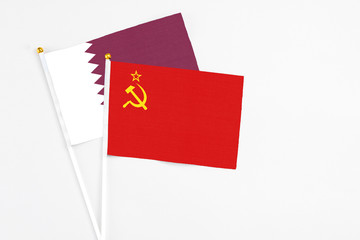 Soviet Union and Qatar stick flags on white background. High quality fabric, miniature national flag. Peaceful global concept.White floor for copy space.