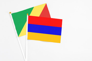 Armenia and Republic Of The Congo stick flags on white background. High quality fabric, miniature national flag. Peaceful global concept.White floor for copy space.