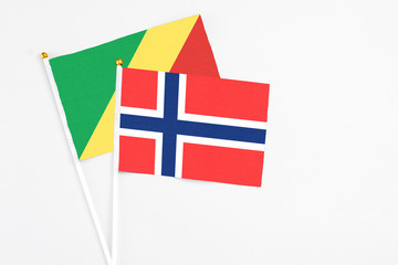 Fototapeta premium Bouvet Islands and Republic Of The Congo stick flags on white background. High quality fabric, miniature national flag. Peaceful global concept.White floor for copy space.