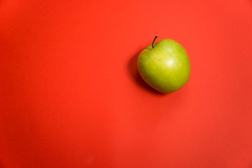 delicious green apple on a red background