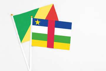 Central African Republic and Republic Of The Congo stick flags on white background. High quality fabric, miniature national flag. Peaceful global concept.White floor for copy space.