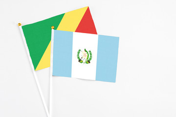 Guatemala and Republic Of The Congo stick flags on white background. High quality fabric, miniature national flag. Peaceful global concept.White floor for copy space.