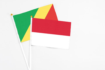 Indonesia and Republic Of The Congo stick flags on white background. High quality fabric, miniature national flag. Peaceful global concept.White floor for copy space.
