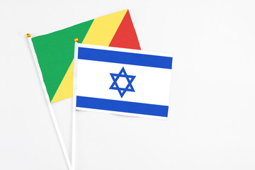 Israel and Republic Of The Congo stick flags on white background. High quality fabric, miniature national flag. Peaceful global concept.White floor for copy space.