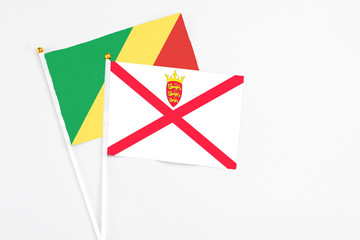 Jersey and Republic Of The Congo stick flags on white background. High quality fabric, miniature national flag. Peaceful global concept.White floor for copy space.