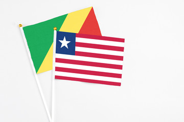 Liberia and Republic Of The Congo stick flags on white background. High quality fabric, miniature national flag. Peaceful global concept.White floor for copy space.