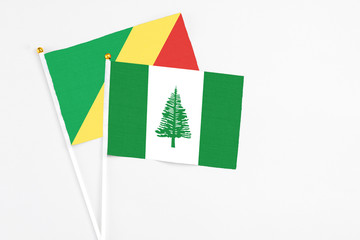 Fototapeta na wymiar Norfolk Island and Republic Of The Congo stick flags on white background. High quality fabric, miniature national flag. Peaceful global concept.White floor for copy space.
