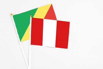 Peru and Republic Of The Congo stick flags on white background. High quality fabric, miniature national flag. Peaceful global concept.White floor for copy space.