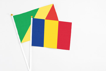 Romania and Republic Of The Congo stick flags on white background. High quality fabric, miniature national flag. Peaceful global concept.White floor for copy space.