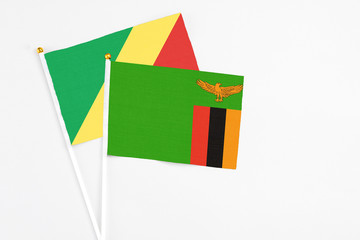 Zambia and Republic Of The Congo stick flags on white background. High quality fabric, miniature national flag. Peaceful global concept.White floor for copy space.