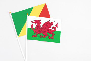 Wales and Republic Of The Congo stick flags on white background. High quality fabric, miniature national flag. Peaceful global concept.White floor for copy space.