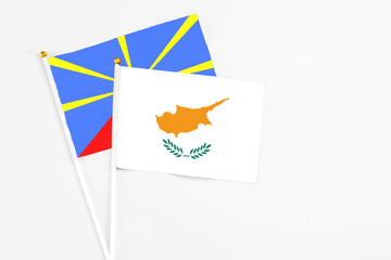 Cyprus and Reunion stick flags on white background. High quality fabric, miniature national flag. Peaceful global concept.White floor for copy space.