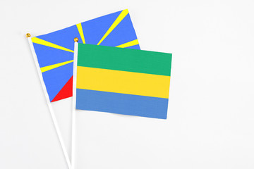 Gabon and Reunion stick flags on white background. High quality fabric, miniature national flag....