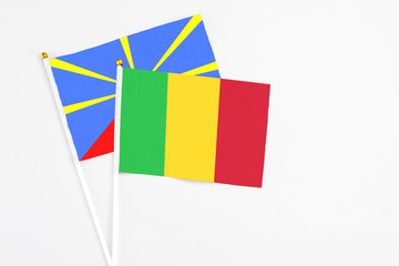 Mali and Reunion stick flags on white background. High quality fabric, miniature national flag. Peaceful global concept.White floor for copy space.