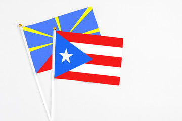 Puerto Rico and Reunion stick flags on white background. High quality fabric, miniature national flag. Peaceful global concept.White floor for copy space.