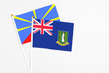 Fototapeta premium British Virgin Islands and Reunion stick flags on white background. High quality fabric, miniature national flag. Peaceful global concept.White floor for copy space.