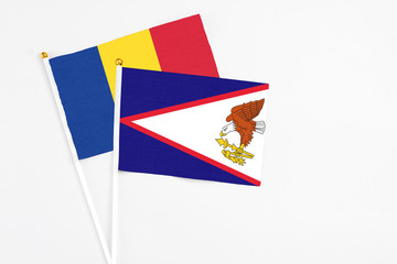 American Samoa and Romania stick flags on white background. High quality fabric, miniature national...