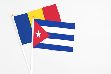 Cuba and Romania stick flags on white background. High quality fabric, miniature national flag. Peaceful global concept.White floor for copy space.