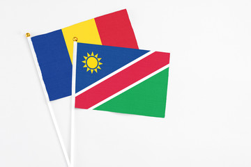 Obraz premium Namibia and Romania stick flags on white background. High quality fabric, miniature national flag. Peaceful global concept.White floor for copy space.