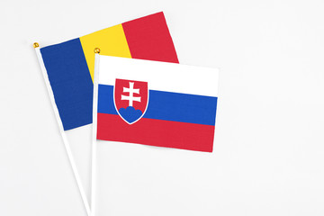 Slovakia and Romania stick flags on white background. High quality fabric, miniature national flag. Peaceful global concept.White floor for copy space.